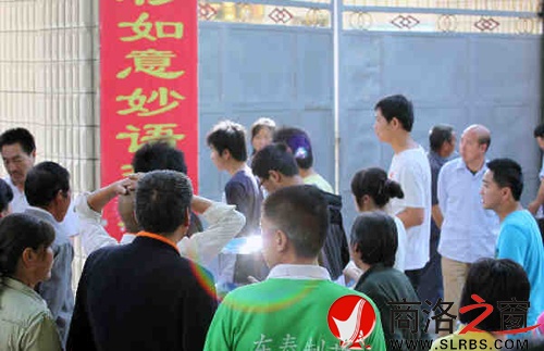 家們送考生進(jìn)入考場(chǎng)時(shí)，一縷光環(huán)閃現(xiàn)鏡頭中，這也許就是人們的理想與期待.jpg
